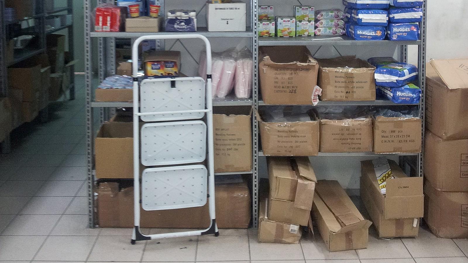 Ladder placed in front of rack with full cardboard boxes