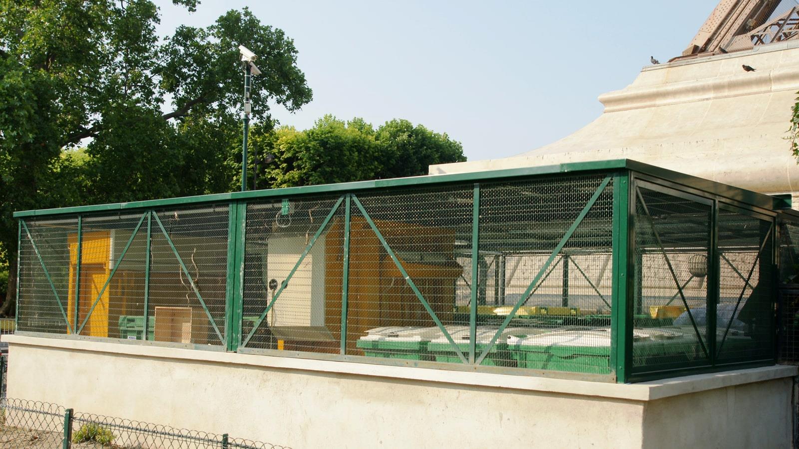 Two Bramidan balers behind green wire fence at the Eiffel Tower